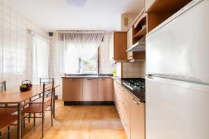 a kitchen with a table and a white refrigerator at Escapada as Rías Baixas A Guarda clima genial in A Guarda