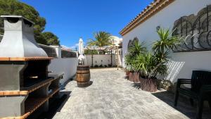 a courtyard of a house with a fireplace and plants at MEDDAYS Villa MARINA in Miami Platja