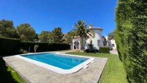 a villa with a swimming pool in front of a house at MEDDAYS Villa MARINA in Miami Platja +19 photos