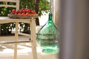 a green glass bottle sitting on a table next to a chair at Masseria Borgo Sentinella in Torre dell'Orso