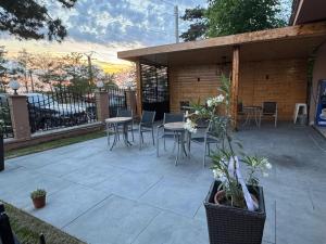 a patio with tables and chairs and a fence at Pensiunea Diamond in Eforie Nord
