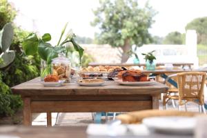 a wooden table with plates of food on it at Masseria Borgo Sentinella in Torre dell'Orso