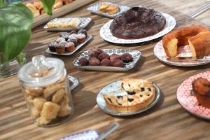 a table topped with plates of pastries and pies at Masseria Borgo Sentinella in Torre dell'Orso