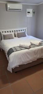 a bedroom with a large bed with white sheets and pillows at Firehouse selfcatering Garden Cottages no 5 in Wellington