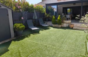 a backyard with two chairs and a fence at Ma maison aux Angles calme climatisée in Les Angles Gard +3 photos