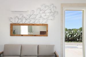 a mirror on a wall next to a couch at Masseria Borgo Sentinella in Torre dell'Orso