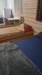 two beds in a room with a table and a tableablishthritisthritisthritisthritis at Mahaidana Kitnet in São Thomé das Letras +2 photos