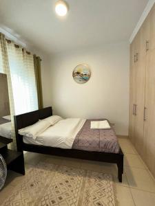 a bedroom with a bed and a clock on the wall at Entebbe Waterfront Home in Kagolomolo