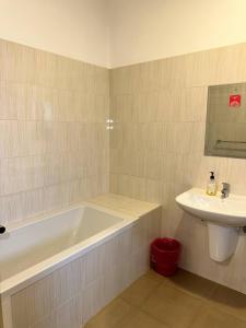 een badkamer met een ligbad en een wastafel bij Entebbe Waterfront Home in Kagolomolo