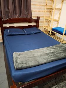 two bunk beds with blue sheets and a blanket at Mahaidana Kitnet in São Thomé das Letras