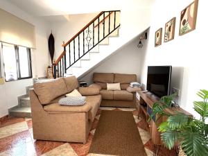 a living room with a couch and a tv at Casa Rural Zahara 21 in Zahara de la Sierra