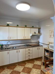 a kitchen with white cabinets and a sink at Casa Rural Zahara 21 in Zahara de la Sierra