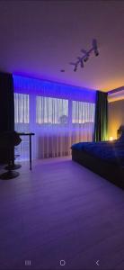 a bedroom with a bed and a table and purple lighting at RVR Apartmanhàz in Sárospatak +6 photos