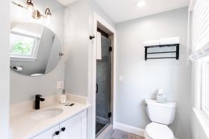 a white bathroom with a sink and a mirror at The Newport Lofts - 410 Thames Street in Newport +20 photos