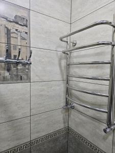 y baño con ducha y toallero de metal. en Central Nest Samarkand, en Samarkand 4 fotos más