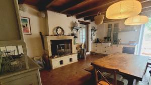 a kitchen with a wooden table and a fireplace at Charming Home with Pool Near Royan & Beaches in Breuillet