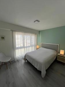 a bedroom with a bed and a chair and a window at Luminoso departamento en el centro de la ciudad in Mar del Plata +25 photos