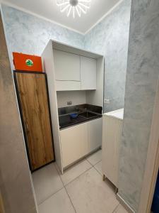 a small kitchen with white cabinets and a door at Margot Sorrento house e spa in Sorrento