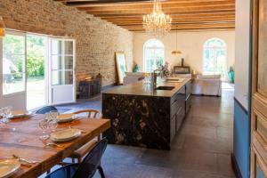 a kitchen and dining room with a table and chairs at Domaine du tertre ychot in Dol-de-Bretagne
