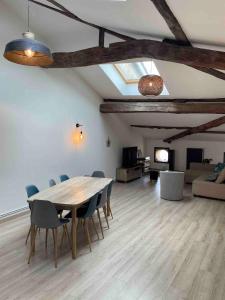 a living room with a wooden table and chairs at Le Colombier Typique & Proche Pistes cyclables in Belleville-en-Beaujolais