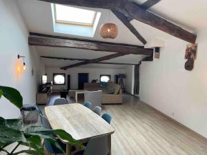 a living room with a table and a couch at Le Colombier Typique & Proche Pistes cyclables in Belleville-en-Beaujolais