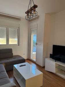 a living room with a couch and a tv at Apartmani Odmor in Podgorica +10 photos