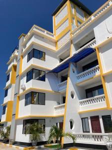 un edificio de color amarillo y blanco en Casa Marabella C3, en Diani Beach