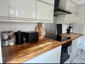 a kitchen with white cabinets and a wooden counter top at Best4Location in Nottingham +8 photos