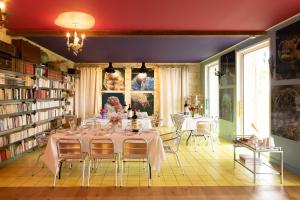 a dining room with tables and chairs in a library at Hostel du chateau in Saint-Émilion
