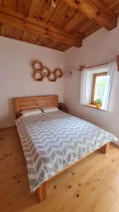a large bed in a room with a window at Soba tete Tile - Hiša ob gozdu in Ptuj