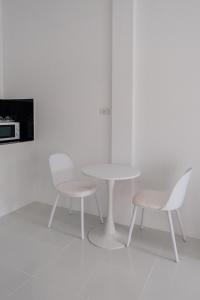 a white table and two chairs and a table and a microwave at SomeNights in Thong Sala