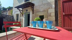 a red table with three blue cups on it at AUX BRIQUES ROUGES Au pied du château et à 4 km du zoo de Beauval in Saint-Aignan