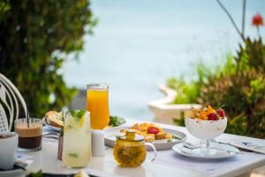 a table topped with plates of food and orange juice at ALS Holiday Houses by Konnect, 900m from Ipsos Beach in Ipsos