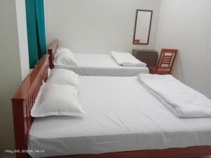 two twin beds in a room with a mirror at SSN Residency in Tiruvannāmalai
