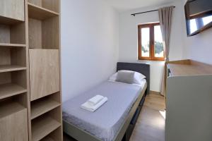 a small room with a bed and shelves at Apartment Ante in Bibinje +58 photos