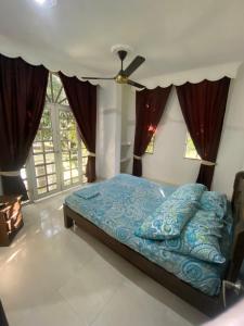 a bedroom with a bed with a blue comforter at VILLA SAMARI 1 Casa campestre con piscina privada in Girardot +31 photos