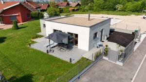 Elle offre une vue sur une maison blanche dotée d'une terrasse. dans l'établissement LA VILLA NATURA, à Granges-Narboz