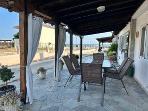 a patio with a table and chairs under a pergola at Evangeo Seaview Apartment Epanomi in Epanomi