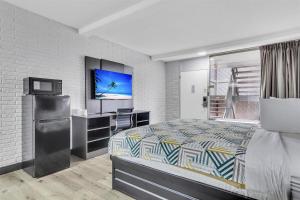 a hotel room with a bed and a television at Motel 6 Summerville, SC Charleston in Summerville