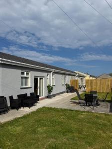 a house with a patio with chairs and a table at Ballyhornan Getaway in Ballyhornan