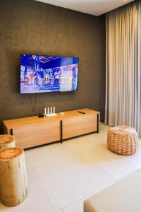 ein Wohnzimmer mit einem Flachbildfernseher an der Wand in der Unterkunft Kamby Milagres - 104 in São Miguel dos Milagres + 12 Fotos