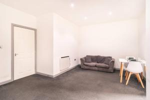 a living room with a couch and a table at Spacious 1 Bed Central Blackburn Apartment in Blackburn