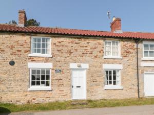 an old brick house with white doors and windows at Brookleigh in Hutton le Hole