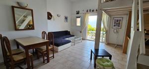 a living room with a blue couch and a table at T1 Pinedda, Studio confort-Vue mer- Calme & soleil in Propriano