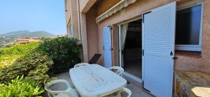 a table and chairs on the balcony of a house at T1 Pinedda, Studio confort-Vue mer- Calme & soleil in Propriano