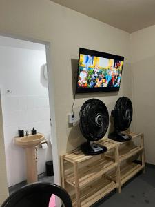 Una habitación con un televisor de pantalla plana en una pared. en Hostel cabo frio, en Cabo Frío
