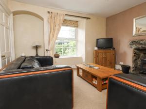 a living room with a couch and a table and a tv at Sygun Cottage in Caernarfon