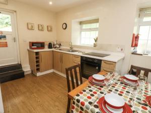 a kitchen with a table with a tablecloth on it at Sygun Cottage in Caernarfon