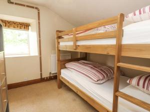 a bunk bed room with two bunk beds and a window at Sygun Cottage in Caernarfon