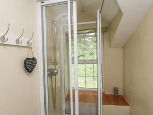 a glass shower in a bathroom with a window at Sygun Cottage in Caernarfon +11 photos